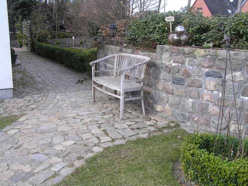 In Verbindung von Natursteinmauer und Weg entstand hier ein sonniger Platz für die kurze Pause zwischendurch.