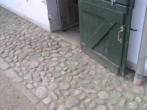 Trockenen Fußes rund ums Haus. Dieser Weg passt zum alten Hofgebäude.