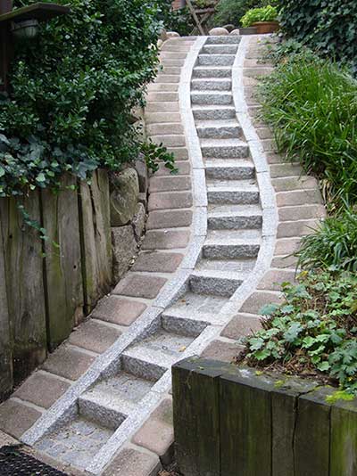 Schwungvoll: Treppe aus einer Verbindung von Granit und Betonsteinelementen.